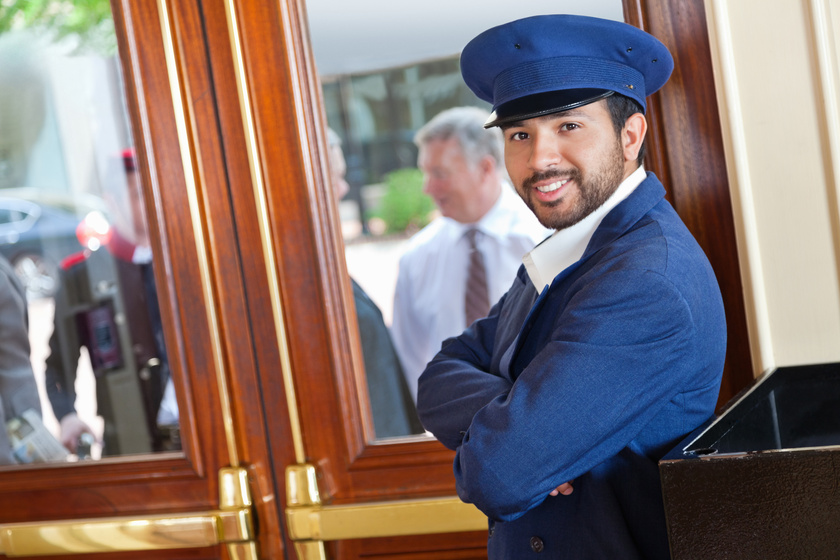 Smiling valet/doorman waiting for guests to arrive at nice hotel